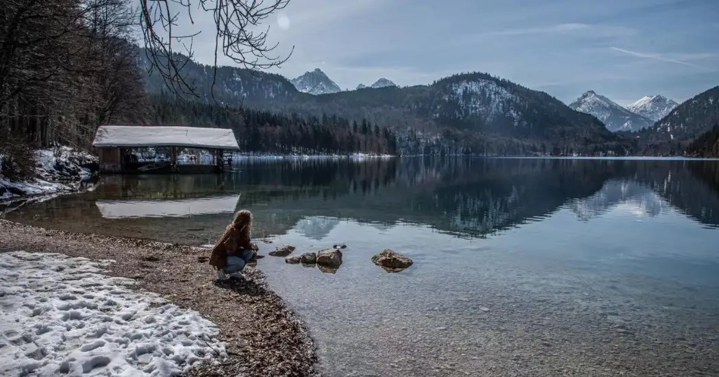 A woman enjoying the view of Alpsee Lake