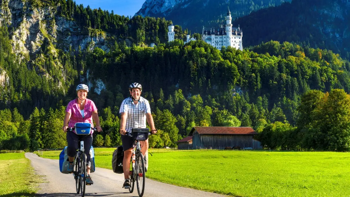 An elderly couple riding the bikes near Neuschwanstein Castle