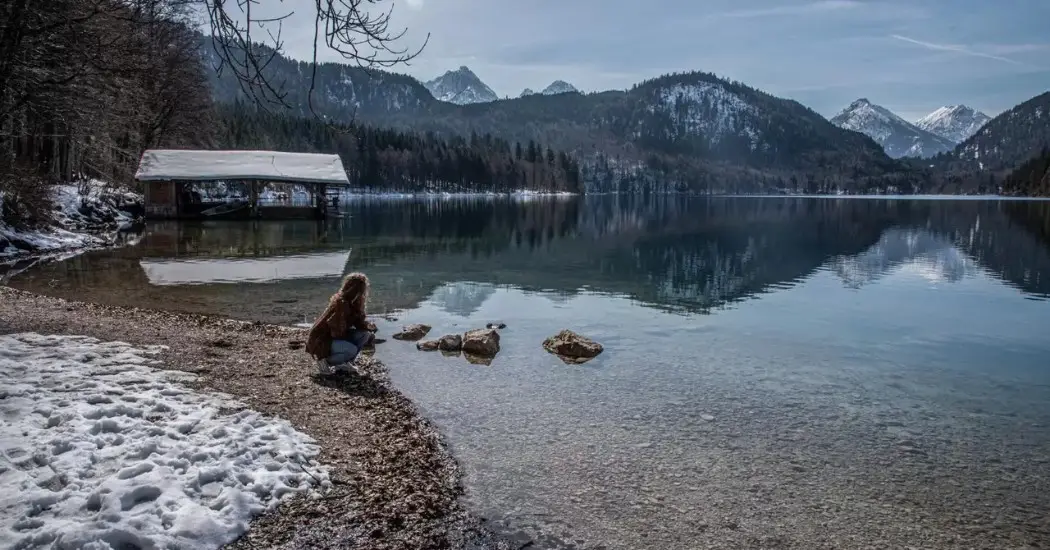 A woman enjoying the view of Alpsee Lake
