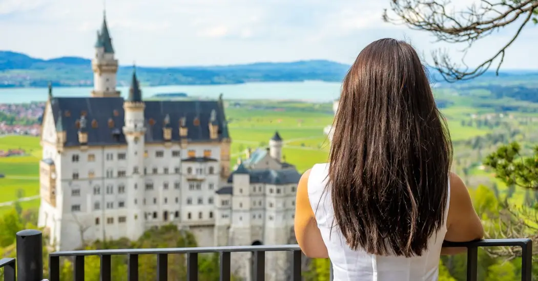 A woman standing on Marienbrücke, looking at the Neuschwanstein Castle